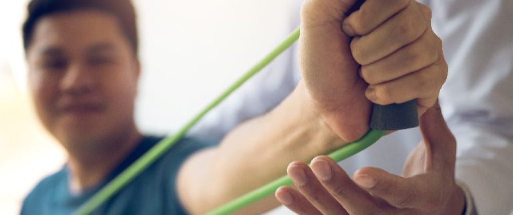 Physical therapist working with a client using resistance bands.
