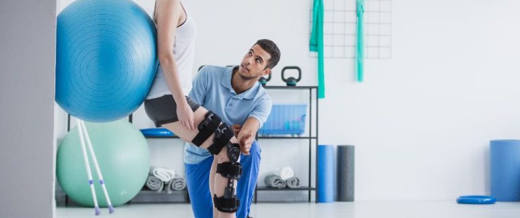 A woman with an injured leg working with a physical therapist.