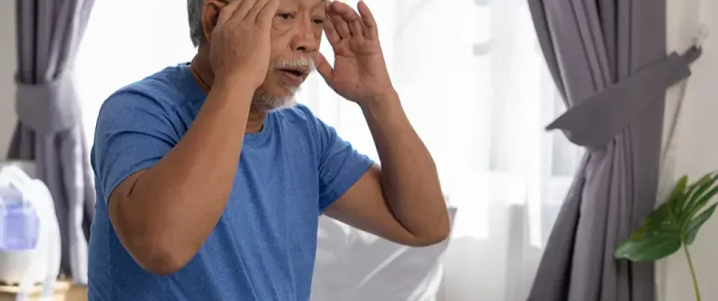 Man holding fingers to his temples because he's dizzy