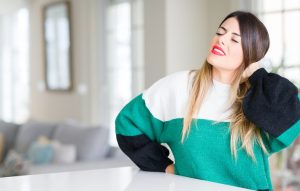 Woman holding her neck as if she has neck pain
