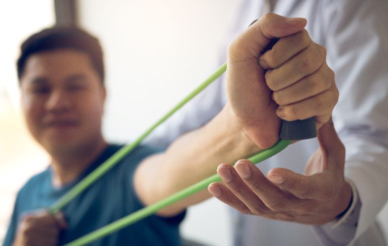 Physical therapist working with a client using resistance bands.
