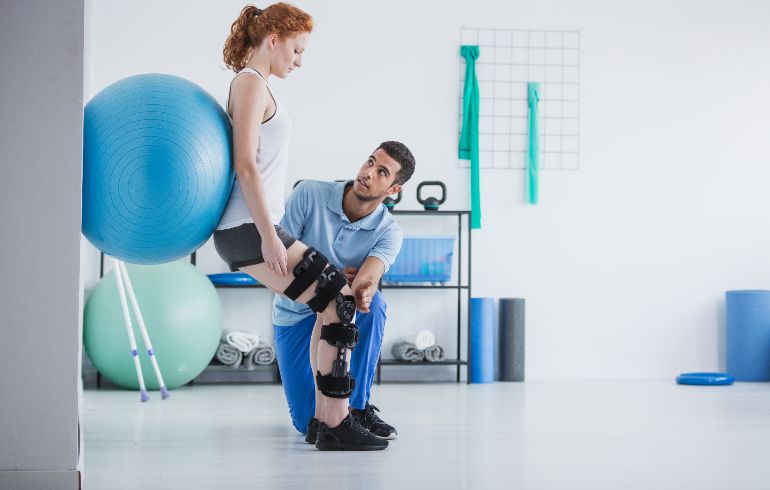 A woman with an injured leg working with a physical therapist.