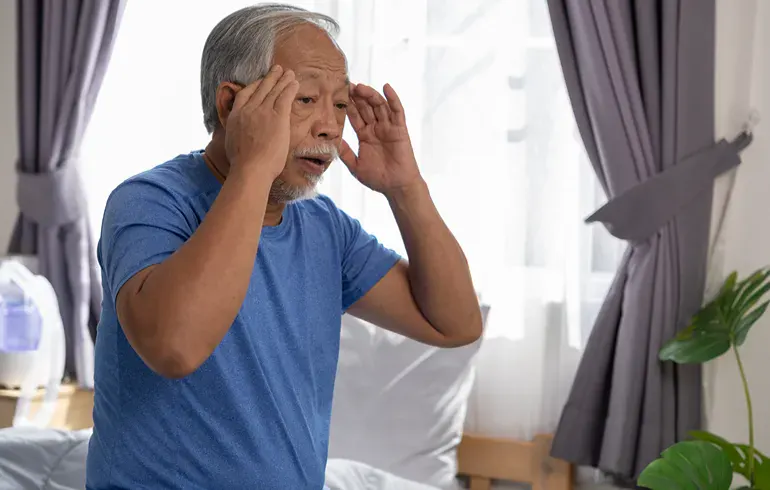 Man holding fingers to his temples because he's dizzy