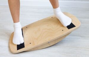 Someone doing physical therapy on a balance board for vestibular and concussion rehabilitation.