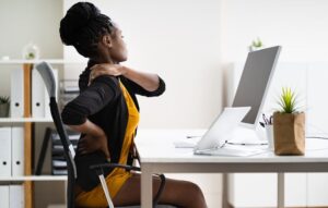 Woman With Back Pain At Desk